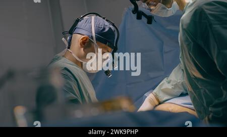 A team of surgeons perform laparoscopic surgery in the operating room ...