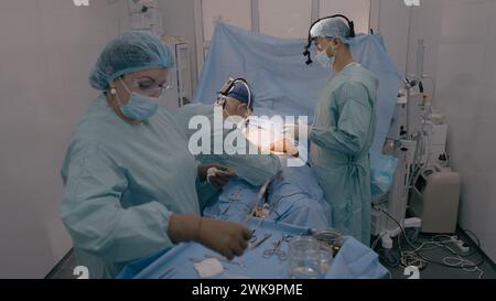 Surgery team professional doctors surgeons perform surgical operation stomach laparoscopy medical equipment nurse assistant give sterile instruments Stock Photo