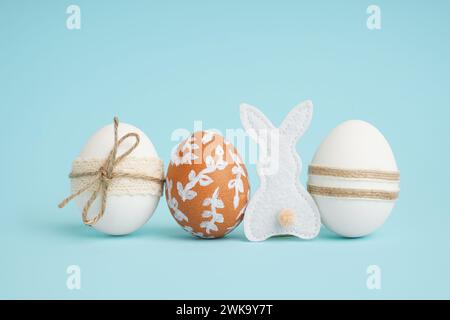 Decorated Easter eggs and fabric bunny on blue background Stock Photo