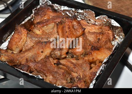 Meat on the ribs cooked on a baking sheet in the oven. Stock Photo