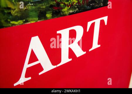 A red sign with white letters that spell the word Art. The sign is photographed at an angle and offers plenty of space for other text. Stock Photo