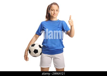 Teenage girl in a football jersey holding a ball and gesturing thumbs up isolated on white background Stock Photo