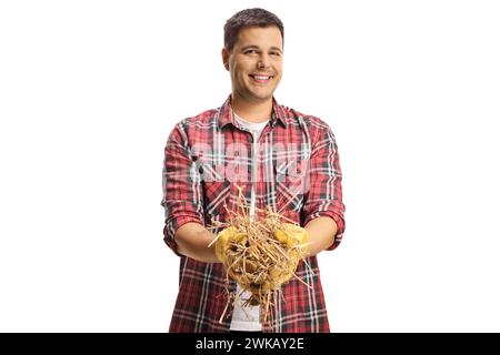 Young man holding a stack of hay isolated on white background Stock Photo