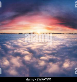Thick clouds in the mountains at dawn. Beautiful aerial landscape with thick fog against dramatic sunset sky. Stock Photo