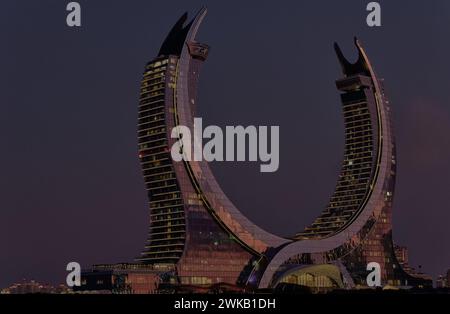 Katara Hospitality Tower, Crescent Tower, in Lusail, Qatar at dusk showing the unique architecture of the illuminated tower Stock Photo