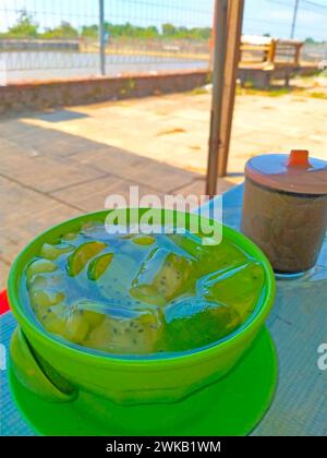 fresh ice in a bowl with lime juice, coconut and melon slices. Stock Photo
