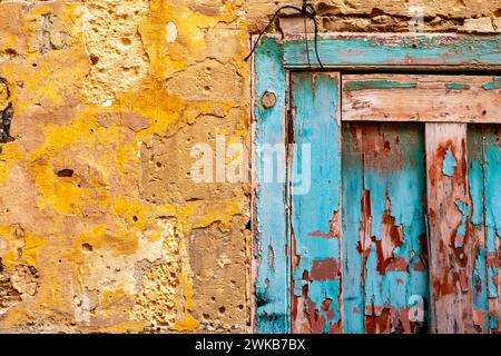 Turquoise door and yellow wall on an old empty house in Malta Stock Photo