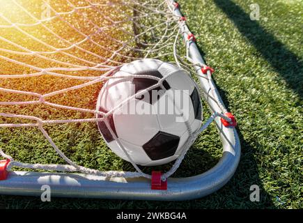 Close up of goal with a soccer ball in net with lens flare Stock Photo