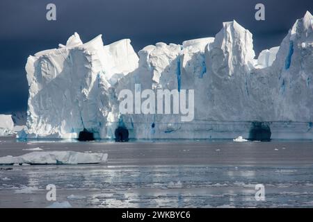 Large iceberg with ice caves broken off from an ice shelf, Antarctic Peninsula, Antarctica Stock Photo