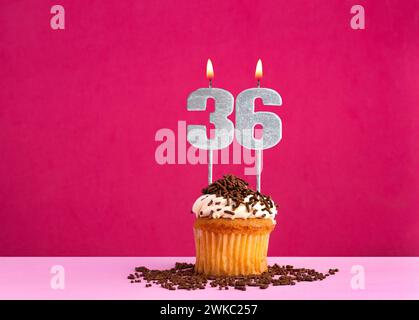 Birthday celebration with candle number 36 - Chocolate cupcake on pink background Stock Photo