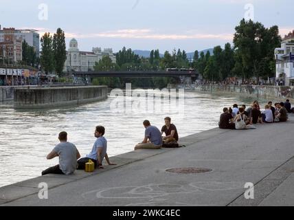 People relaxing in summer temperatures on the banks of the Danube Canal in Vienna, 19 July 2019 Stock Photo