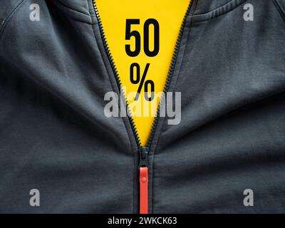 Opened zipper of a hoodie showing 50 percent sale offer on yellow price tag. Sale discount on fashion outlet and clothing price promotion. Stock Photo