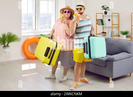 Happy couple of fat woman and smiling man in hats and sunglasses getting ready for holiday trip. Stock Photo