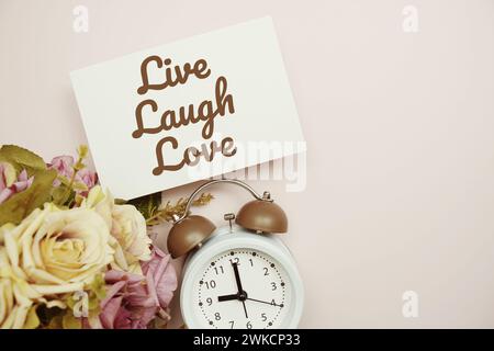 Live Laugh Love  Card with colorful flowers border frame on pink background Stock Photo