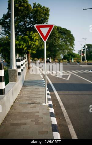 Triangular road sign, sign three-way junction on the road in Kediri, East Java, Indonesia Stock Photo