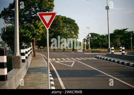 Triangular road sign, sign three-way junction on the road in Kediri, East Java, Indonesia Stock Photo