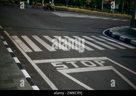 Road junction, stop word marking on road in Kediri, East Java ...