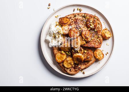 French toasts with caramelized banana and pistachios, top view. Stock Photo