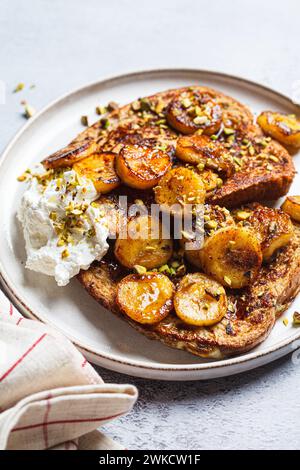 French toasts with caramelized banana and pistachios. Stock Photo
