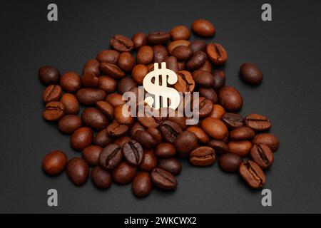 Golden dollar sign nestled within a pile of roasted coffee beans against a sleek black backdrop. Coffee price to taste ratio concept. Stock Photo
