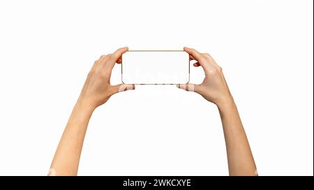 Isolated unrecognisable touchscreen mobile phone with golden yellow frame in female hands, horizontal screen position. Stock Photo