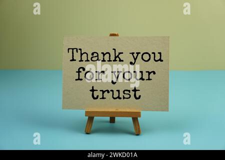 Thank you for your trust text message written on paper card with alarm clock on blue and yellow background Stock Photo
