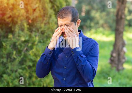 Man covering eyes by hand of bright sunlight Stock Photo