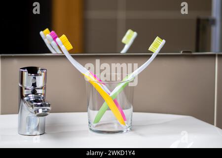 Toothbrushes in glass on blurred background at bathroom Stock Photo
