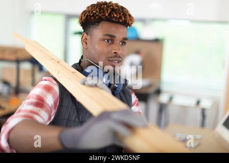 manley construction worker holding wood planks Stock Photo
