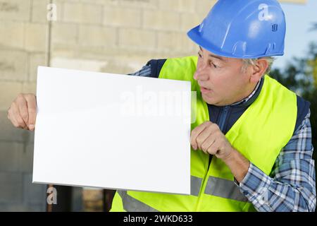 happy builder holding white board Stock Photo