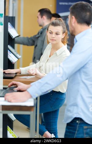 young lady looking across to see screen of friends computer Stock Photo
