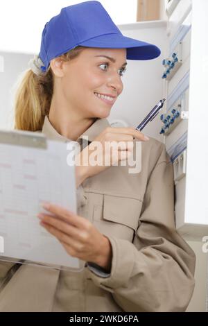a lady inspecting fuse board Stock Photo