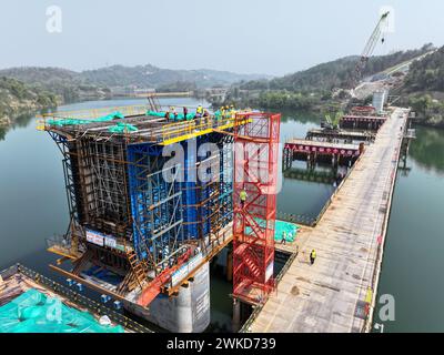 Chongqing. 19th Feb, 2024. An aerial drone photo shows staff members working at the construction site of the Xuantianhu bridge of the middle line of the Chengdu-Chongqing high-speed railway in southwest China's Chongqing, Feb. 19, 2024. The middle line of the Chengdu-Chongqing high-speed railway will slash the travel time between the two cities to just 50 minutes after completion. Credit: Tang Yi/Xinhua/Alamy Live News Stock Photo
