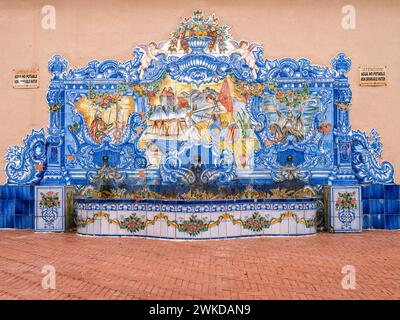An ornate ceramic tiled water feature and bench in the ancient part of Orihuela, Alicante, Spain. Stock Photo