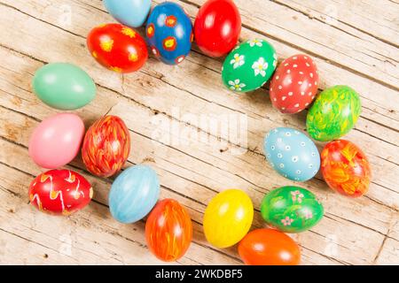 Assorted hand-painted easter eggs on rustic wood backdrop Stock Photo