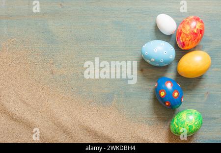 Assorted hand-painted easter eggs on rustic wood backdrop Stock Photo