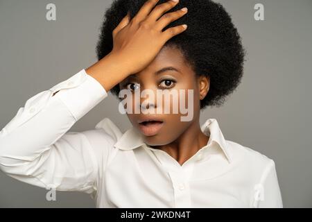 Forgetful black woman touching head with shocked amazed face expression, remembering forgotten thing Stock Photo
