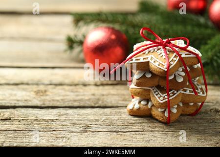 Tasty Christmas cookies with icing on wooden table. Space for text Stock Photo