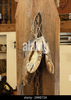 Old white leater woman shoes hanging on the wall Stock Photo