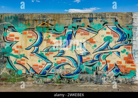 Colorful artistic graffiti on the wall of the dike or levee at maritime port of Varna, Bulgaria, Europe, EU Stock Photo