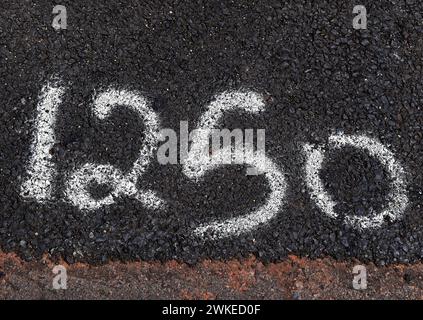 Number 1250 painted with spray paint on the asphalt of the street Stock Photo