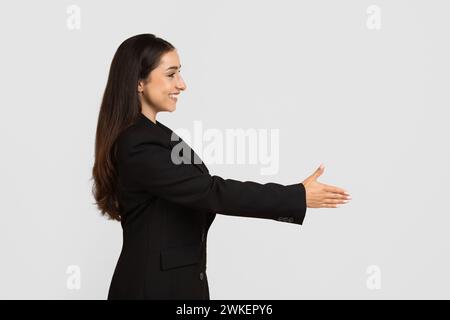 Professional woman in suit offering handshake, side view Stock Photo