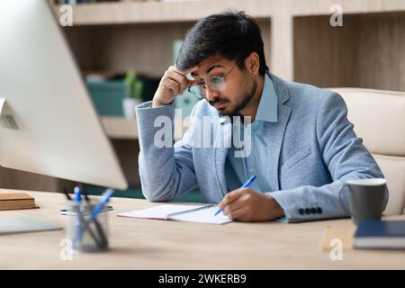 Focused Middle Eastern Businessman Analyzing Information on Computer In Office Stock Photo