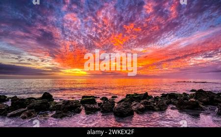 Brilliant red clouds in the sky at sunset over the Gulf of Mexico at Caspersen Baech in Venice Florida USA Stock Photo