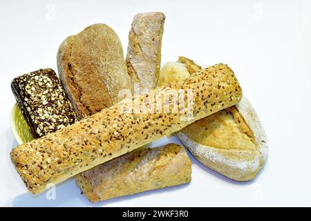 Bread, different in shape, taste and preparation technology, lies on a white table. Stock Photo