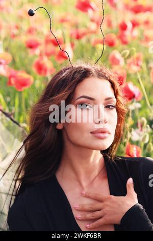 girl in a field of poppies in a black bodysuit . glamor photo Stock Photo