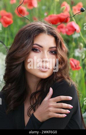 girl in a field of poppies in a black bodysuit . glamor photo Stock Photo