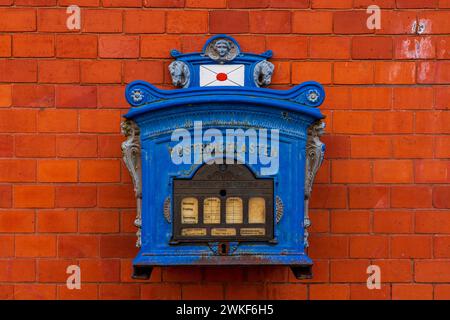 Blue mailbox on red brick wall. Stock Photo