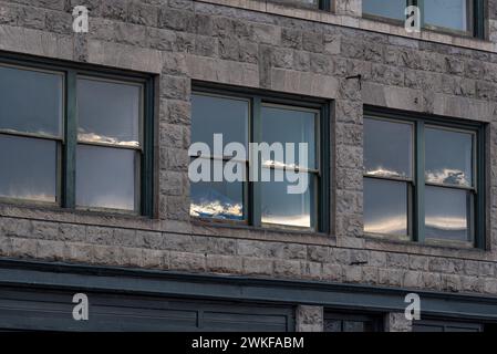 Mountains reflected in the windows of a building in Baker City, Oregon. Stock Photo