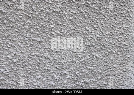 Gray, prickly, pimply texture of wall plaster with a uniform, uniform coating. Plaster for walls based on quartz sand and cement. Stock Photo